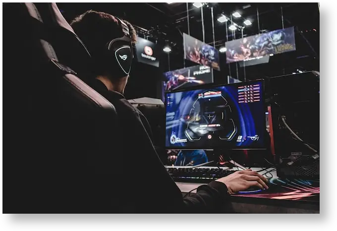 An esports gamer sitting in front of a computer on a stadium